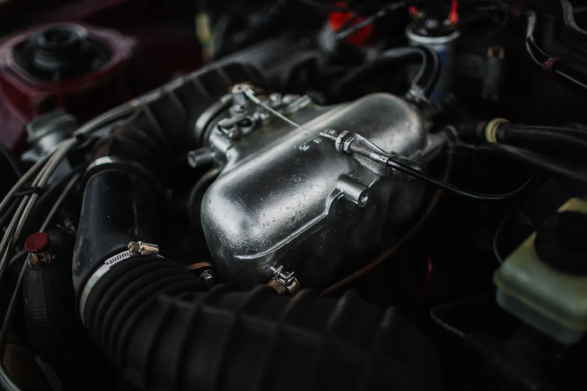 Close-up of engine components and hoses under a car bonnet
